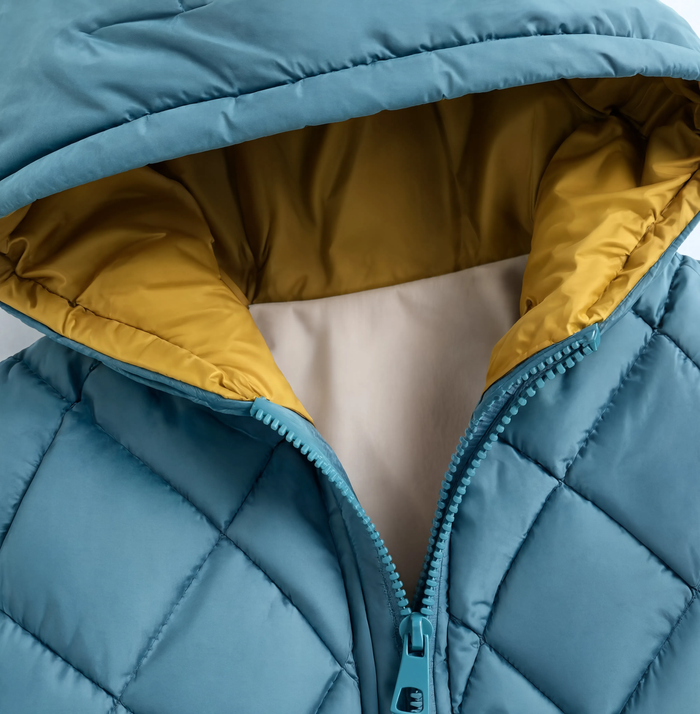 Gros plan sur le col et la capuche de la parka enfant bleu canard