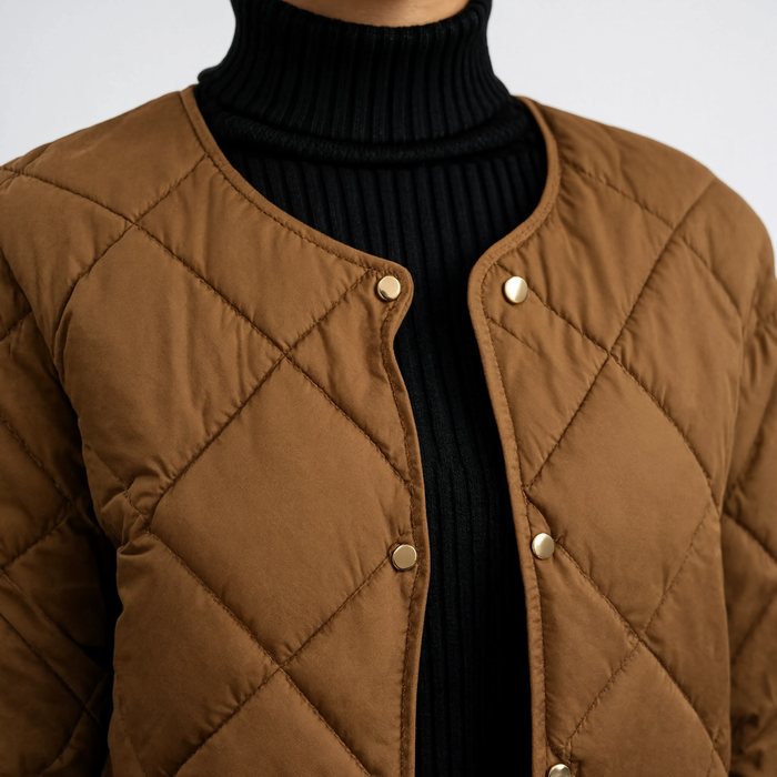 Zoom sur le col rond et les boutons dorés du manteau matelassé L'Opaline marron